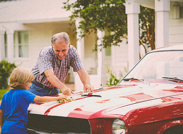 child and grandfather cleaning classic car